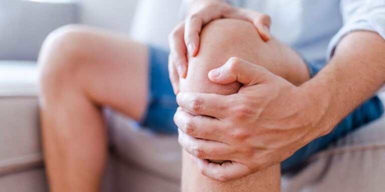 man holding his knee in pain