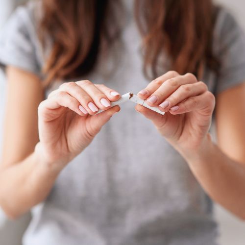 young woman breaking a cigarette in half