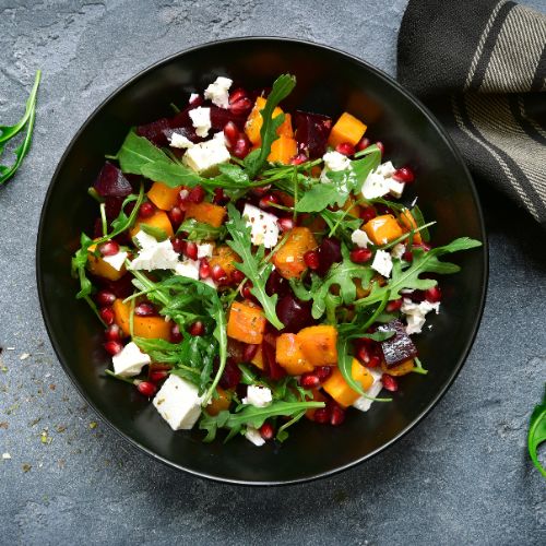 colorful salad in a black bowl on dark gray slate