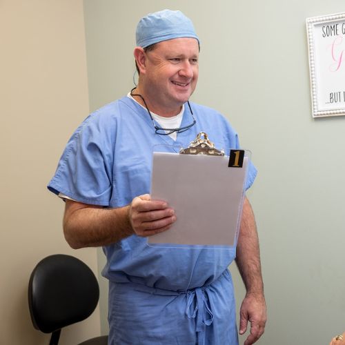 Dr. Christopher Pollack standing while holding a clipboard