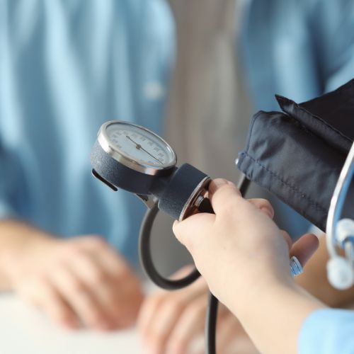 physician assistant examining a patient’s blood pressure