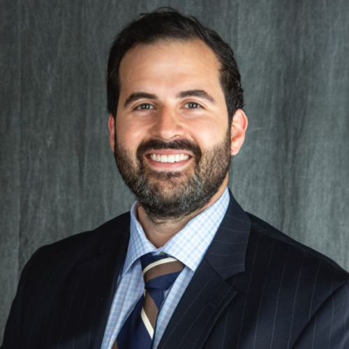 Dr. Lodeiro in a suit and tie posing for a photo