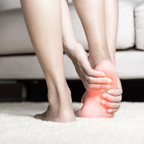 woman in her living room experiencing plantar fasciitis