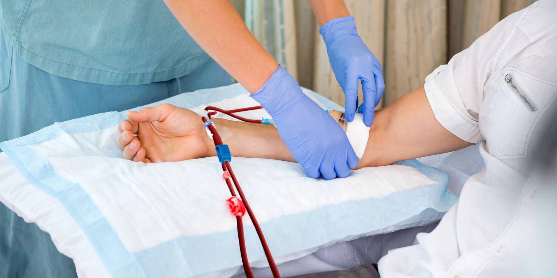 Nurse in renal unit at hospital starting dialysis on patient