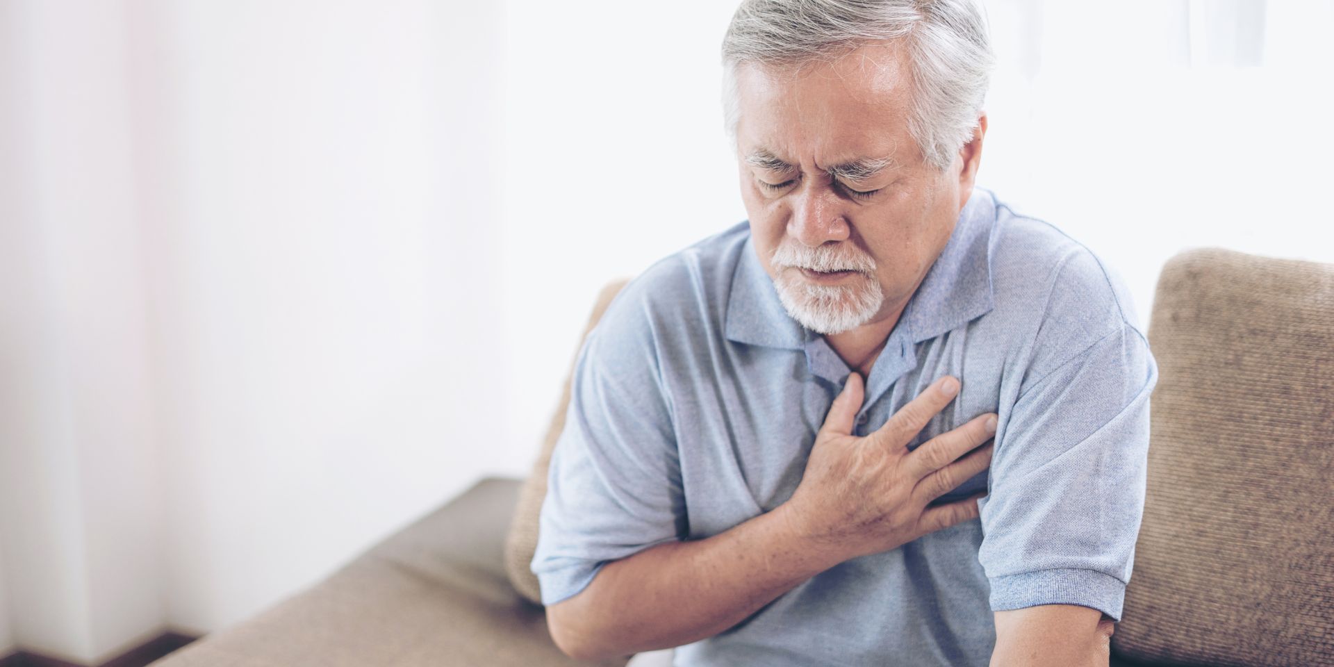 Man holding his chest in pain due to aortic aneurysm symptoms before rupture