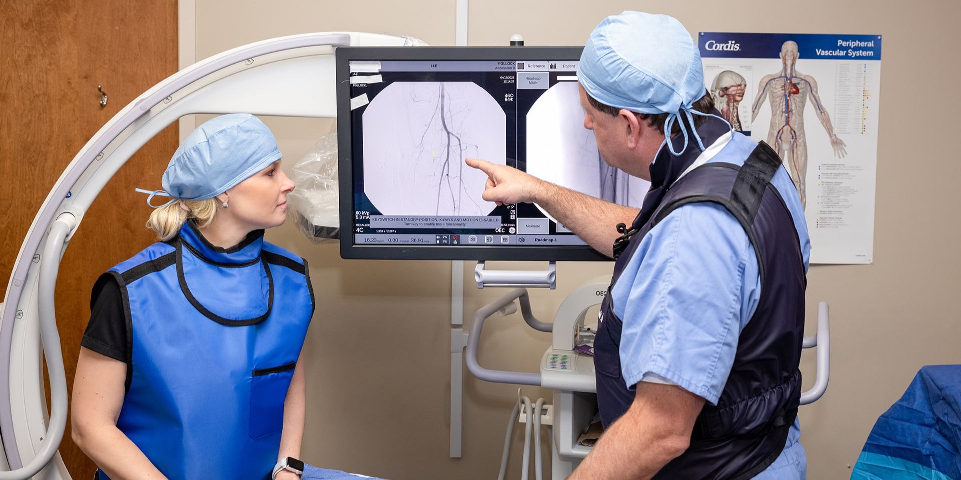 vascular surgeon talking with patient while examining an X-ray