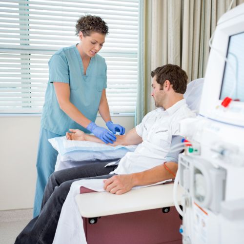 Female nurse preparing a man for dialysis