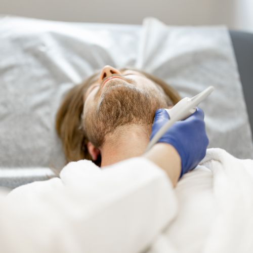Man lying down as a doctor’s applies an ultrasound to examine the carotid artery