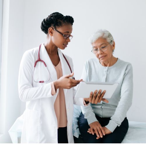 Doctor telling her older female patient about chronic venous insufficiency