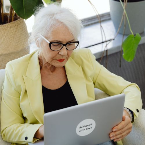 older woman sitting in a chair researching when to get varicose veins treated