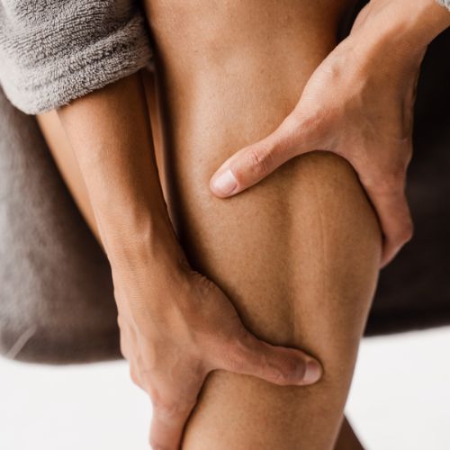 woman touching her legs and looking at her veins