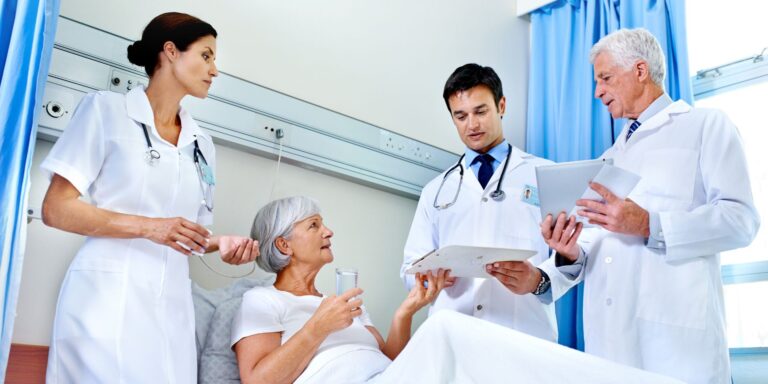 team of doctors talking to an older female patient in a hospital bed