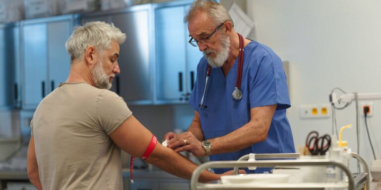 vein doctor applying a bandage to a patient after drawing blood