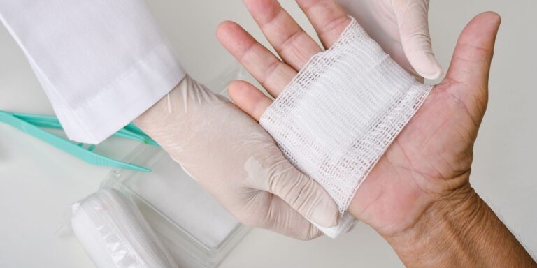 doctor applying a bandage to a patients non-healing wound