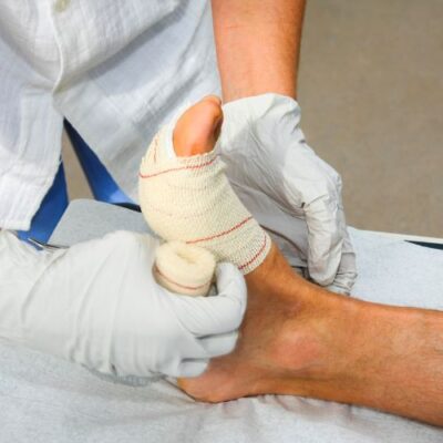 doctor applying a bandage to a patient’s foot